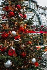 Golden red Christmas balls and toys hanging on the Christmas tree, festive details and winter decorations outdoor