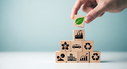 Hand arranging wooden blocks with green leaf and industry icon for sustainable development concept with copy space