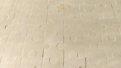 Light Wooden Jigsaw Puzzle surface texture with a shallow depth of field, creating a background for connection, business, and problem-solving concepts.