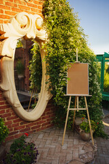 Artistic corner with a mirror and blank easel in a garden