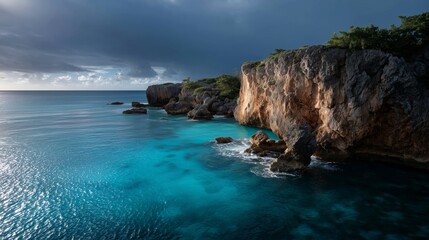 Scenic view of a rugged coastline with clear blue water under a cloudy sky