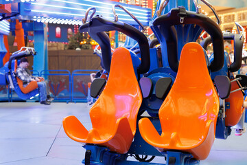 Fototapeta premium An amusement park attraction without people. Empty seats on a swing ride.