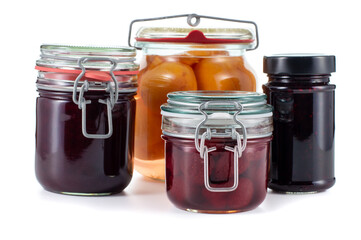 Homemade fruit preserves including strawberry jam, peach compote, plum butter and blackberry jam isolated on a white background, ideal for food, recipe or kitchen themed projects