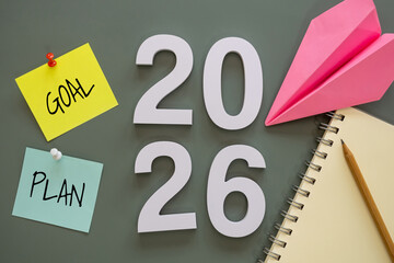 number of New Year 2026 with word goal and plan on post-it paper pin on green background, notebook,...