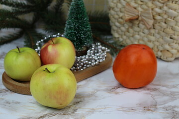 Winter apples and persimmons stand on the table on winter days