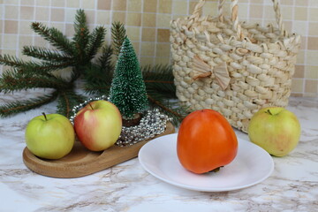Winter apples and persimmons stand on the table on winter days