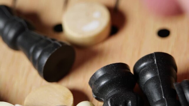 Board Game Pieces Mixing inside wooden storage box, close-up movement of chess, checkers and backgammon tokens, creating rich clattering sound, highlighting tactile strategy gaming elements and cozy