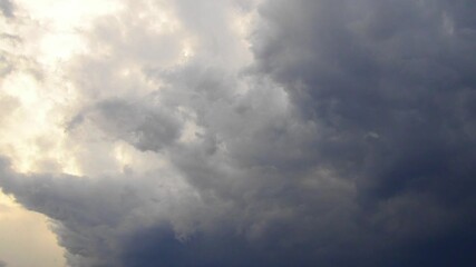 Time lapse of beautiful white clouds in sky. Volumetric light effect. Sunrays are hidden behind approaching dark clouds. Cumulus convection in troposphere. Cumulonimbus sunset and sunrays rapid motion - Powered by Adobe