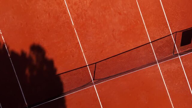Bird view drone flight scanning the full tennis clay court in Italy, Italia, capturing a bright summer sports atmosphere