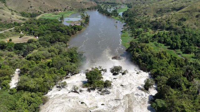Drone shot of the Kwanza River approaching Binga Falls, Angola, where calm waters suddenly transform into thunderous cascades amid lush rainforest