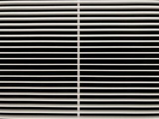Obraz premium Abstract geometric background featuring a symmetrical pattern of clean, parallel white louvers and dark shadows from a modern ventilation grille