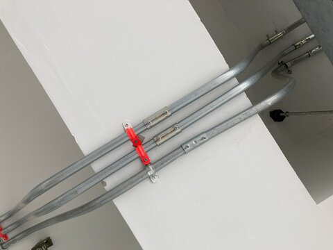 Detailed view of a flat aluminum lightning conductor system installed on the interior ceiling of a modern building