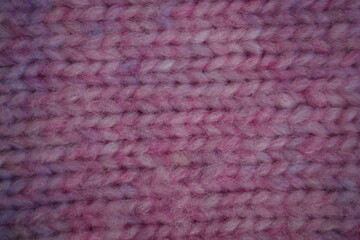 High-resolution close-up of a knitted fabric texture in mixed purple and blue tones. The soft woven surface shows detailed threads, creating a cozy and tactile background. Ideal for use in textile des