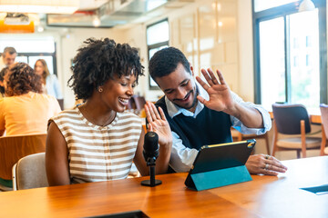 Coworkers smiling and waving during a video podcast recording