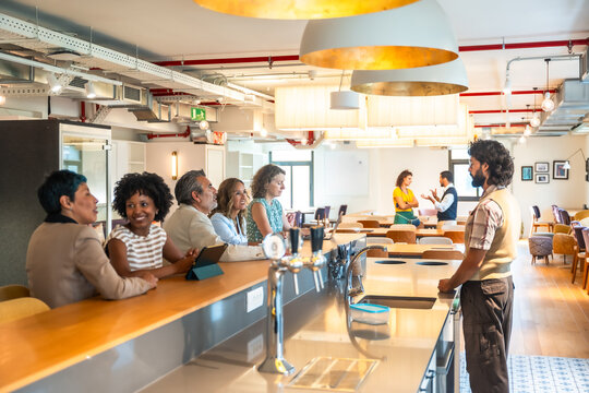 Coworkers socialising and networking during a break in coworking office