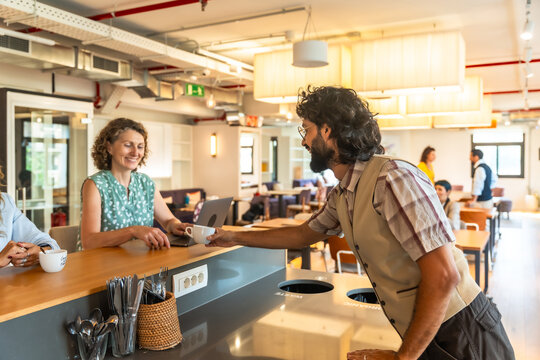 Coworkers sharing coffee break in modern coworking office