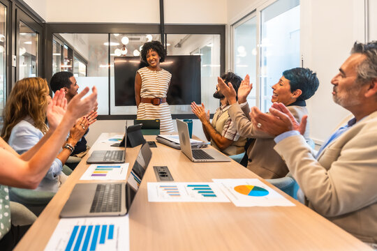 Diverse business team applauding successful presentation in modern office