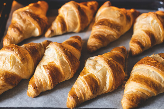 Top view on croissants on baker's paper on baking sheet.
