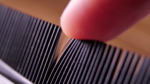 Finger Running Across Plastic Comb Creating Twanging Friction Sound Close up View Hygiene Beauty Hair Care ASMR Concepts Detailed Texture Visual Sound Design Element