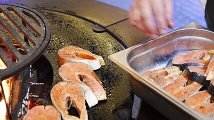 Cooking salmon on an open grill at a summer event