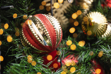 Christmas tree with red ball and lights garland. Xmas card. Close up. Winter. Outdoors.