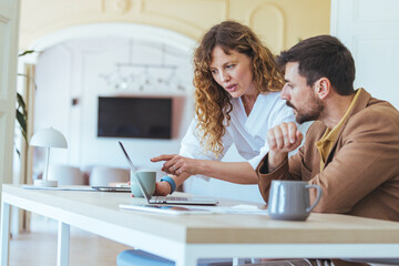 Collaborating Business Meeting At Home Office: Woman And Man Discussing Documents And Laptop