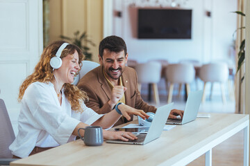 Smiling Colleagues Collaborate at Modern Office With Laptops and Headphones