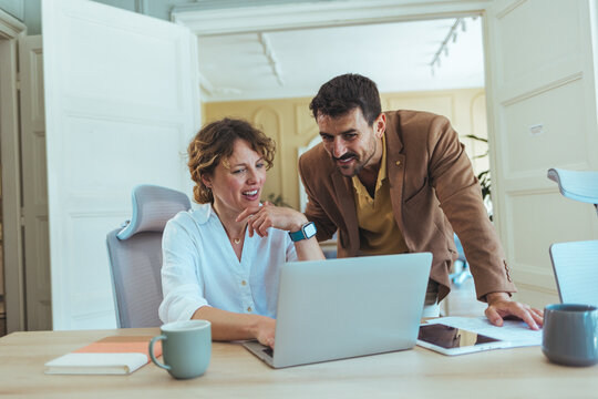 Collaborative Teamwork: Colleagues Review Projects On Laptop During Office Meeting