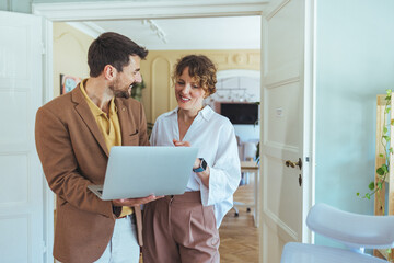 Business Partners Review Laptop Screen During Friendly Office Meeting At Home Office Space