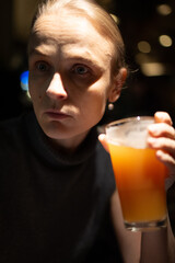 Thoughtful woman holding orange juice