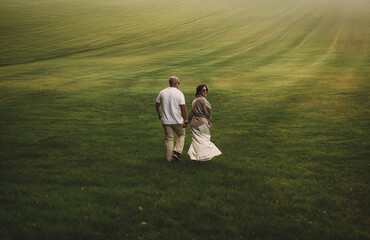 beautiful couple walks through a vast field