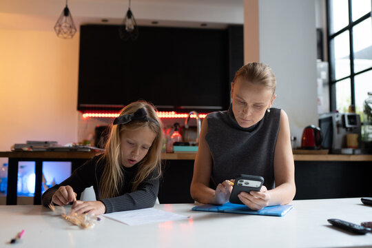 Mother and daughter working at kitchen table