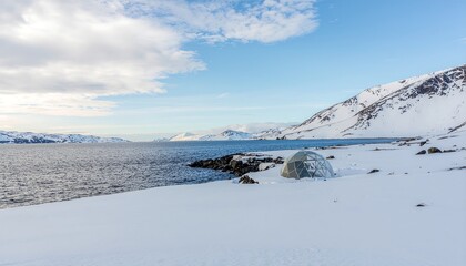 Snowy Coastal Landscape Arctic Scenery with Mountains, Sea, and Blue Sky Under a Cloudy Day
