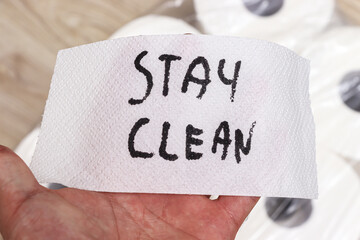 Handwritten note on a paper towel emphasizes the importance of hygiene with the message stay clean. The paper towel is held in a hand, providing a personal touch.