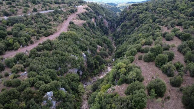 Rocky gorge beside national road with Mediterranean shrubs in Greece