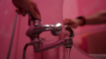 Bathroom Faucet Aerator Mixing Water and Air in Pink Wall Setting, Close-up Flowing Water Demonstrating Efficient Consumption, Eco-Friendly Plumbing Feature,Modern Bathroom Hygiene, Liquid Interaction