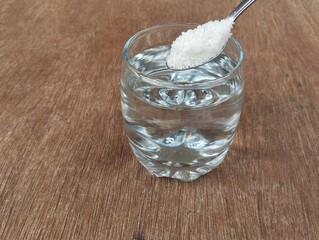 Salt water solution in glass on wooden table background, High angle view	