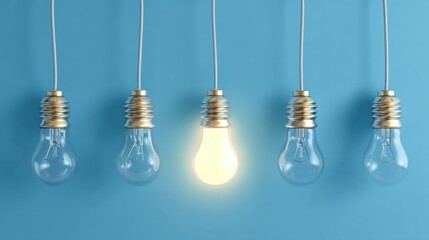 Five hanging light bulbs against a blue backdrop, four unlit with visible filaments, one central bulb glowing brightly,