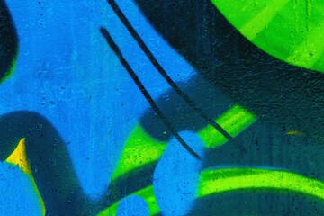 Abstract graffiti art on urban wall with blue, green, black shades. 90s style, street art, bold shapes. Background, walls, creative spaces, modern 90s flair.