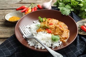 Chicken tikka masala with rice served on wooden table, closeup