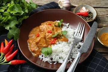 Chicken tikka masala with rice served on wooden table, closeup