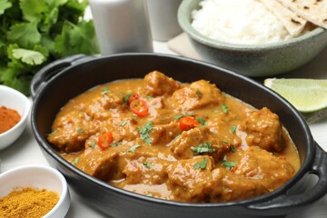 Chicken tikka masala, rice and spices on white table, closeup