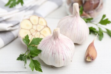 Garlic and parsley on white table, closeup