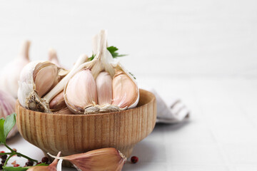 Garlic and parsley on white table, closeup. Space for text