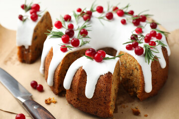 Tasty Christmas cake with cranberries and knife on light table, closeup