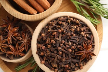 Different spices in bowls and fresh rosemary for mulled wine on table, top view
