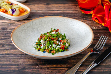 Close-up of fresh herb salad with crumbled cheese and tomatoes