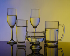 Assorted glassware with colored reflections studio photography, horizontal
