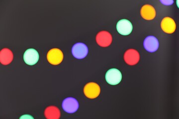 Bright Christmas lights on gray background, bokeh effect