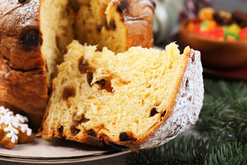 Tasty panettone cake, candied fruits and Christmas decor on table, closeup